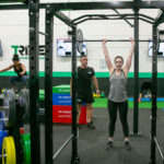 Tribe41 member using the barbell with a coach watching over her